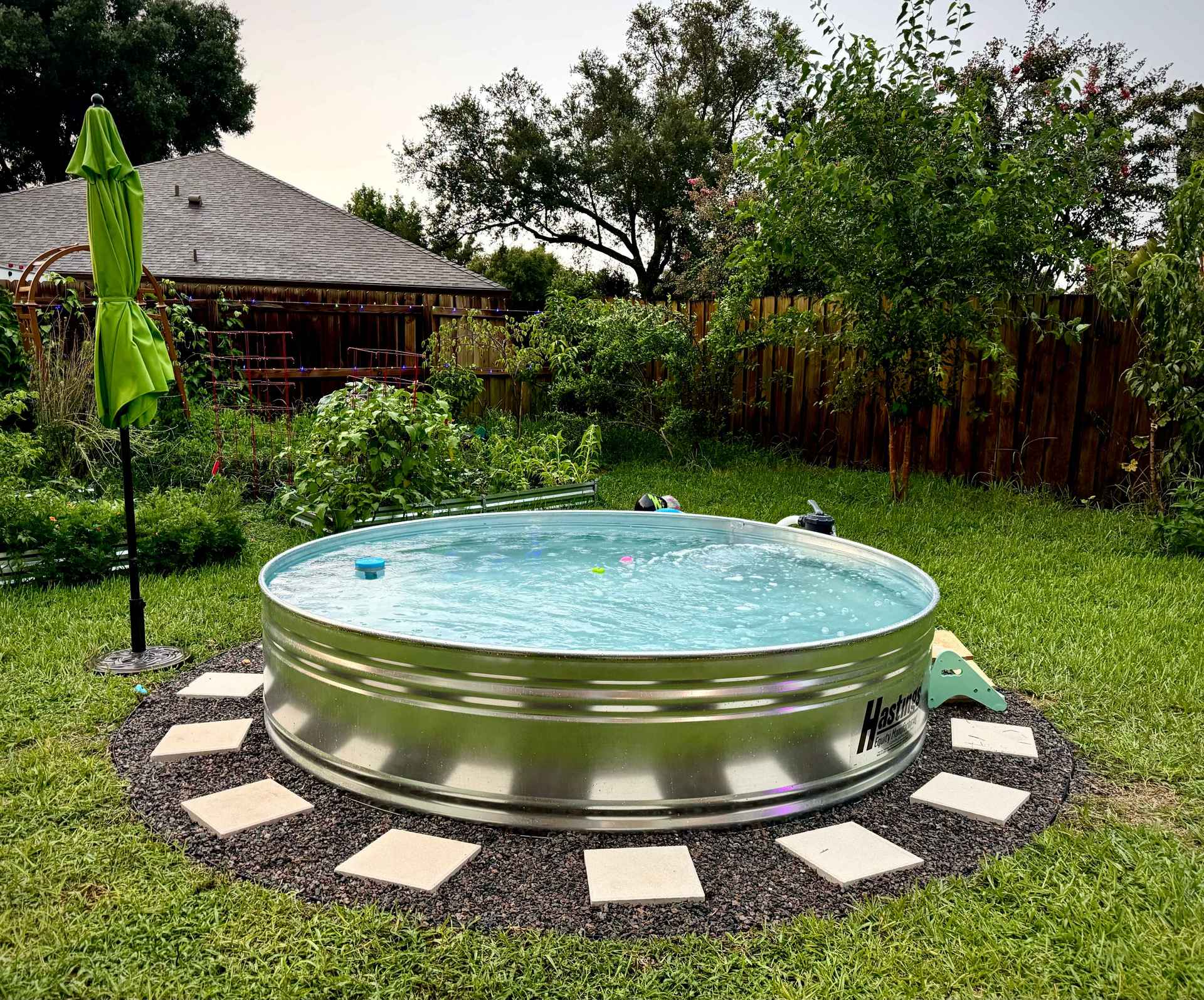 Backyard pavers and stone around an above ground pool