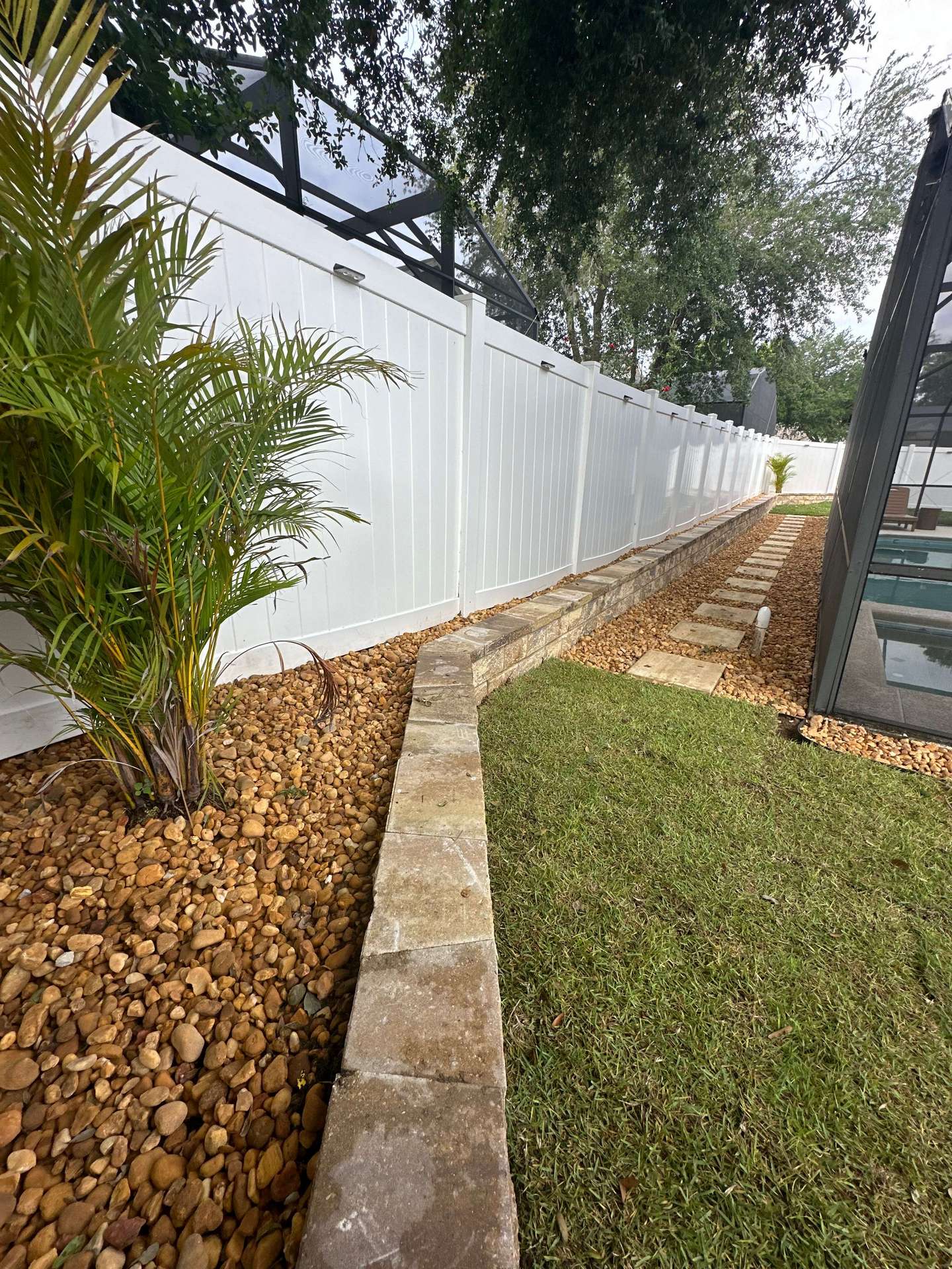landscaping and paver path around the side of a backyard